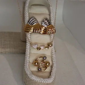 Ανακαλύψτε το κομψό Romantic & Modern Gold Collection Σετ Κοσμημάτων Ατσάλι 18K που συνδυάζει ρομαντισμό, vintage αισθητική και minimal πολυτέλεια. Περιλαμβάνει κολιέ καρδιά με ζιργκόν, επιχρυσωμένα σκουλαρίκια 18K και minimal δαχτυλίδι. Ιδανικό για καθημερινές και βραδινές εμφανίσεις ή ως μοναδικό δώρο.